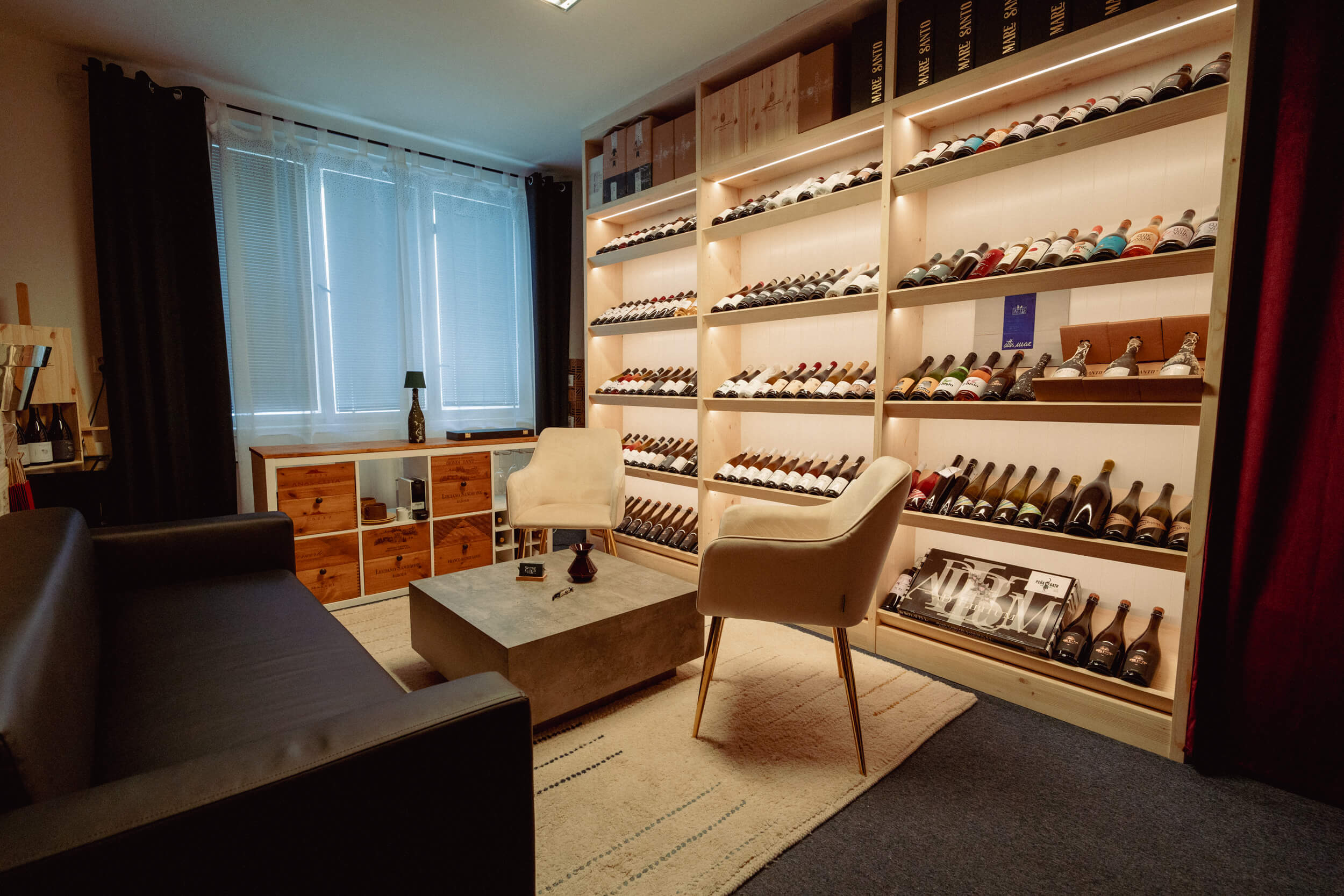 Posezení a osvětlená vinotéka v showroomu Sense of Wine